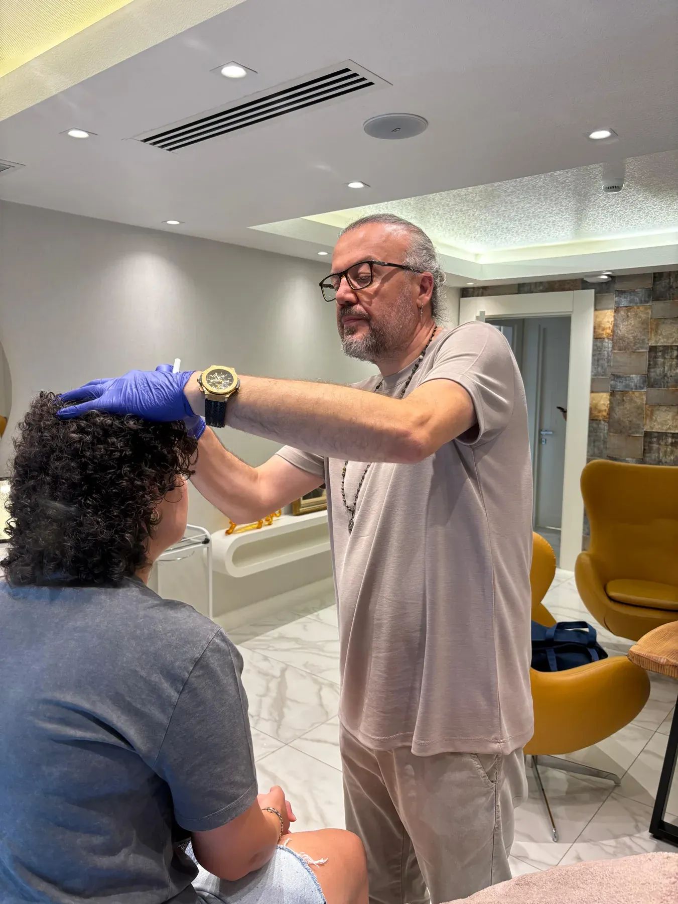 Op. Dr. Ömer Lütfi Aksoy kliniğinde uygulama öncesi yüz bölgesini değerlendirirken